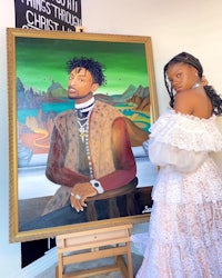 a woman in a white dress standing next to a painting